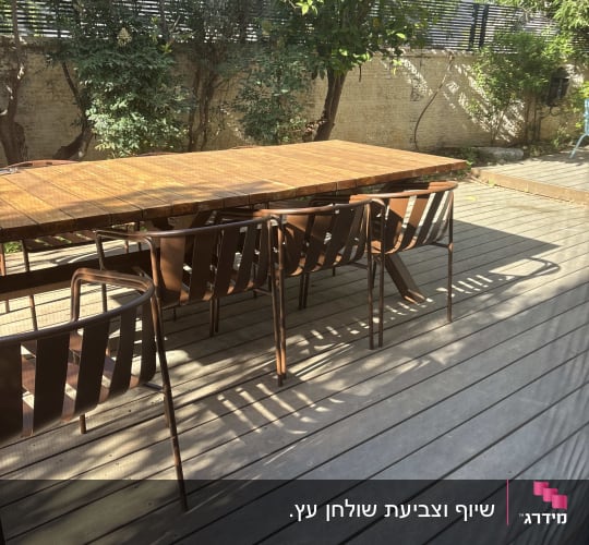 שולחן וכיסאות על דק עץ בגינה